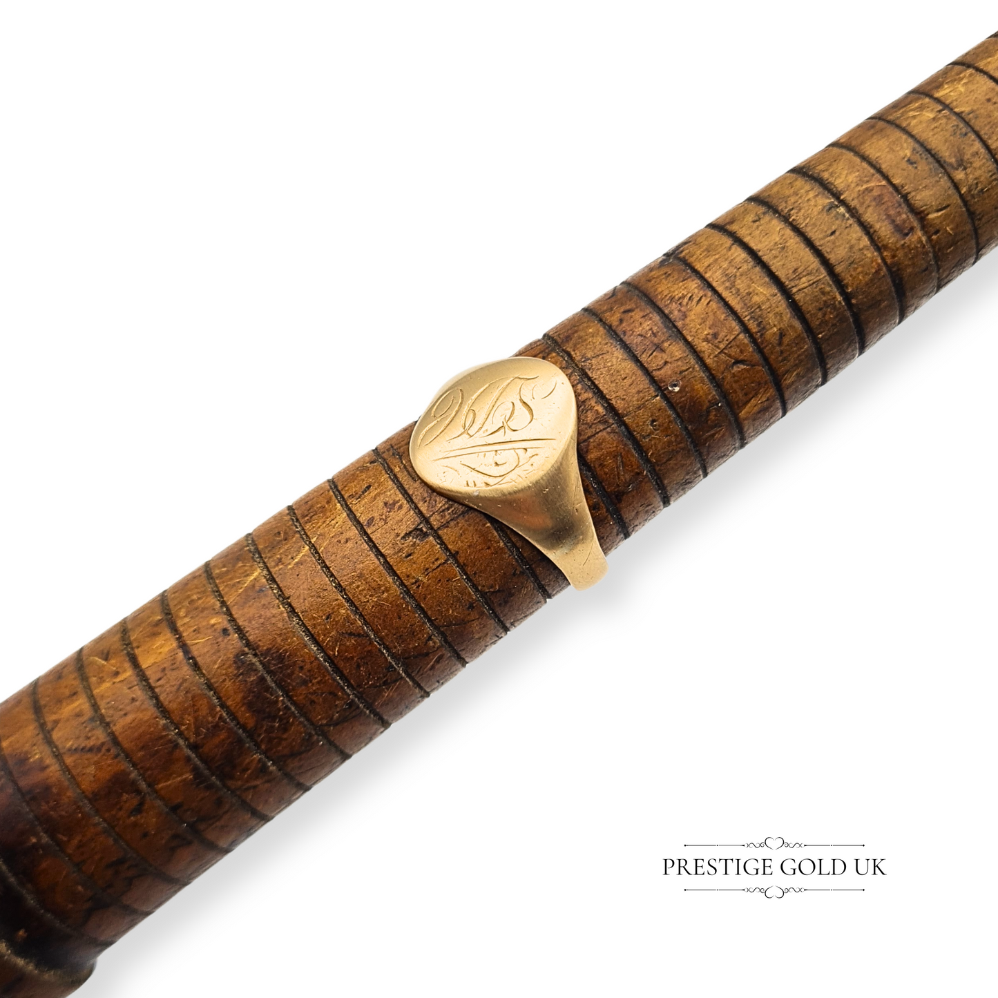 Wooden Sizer with a gold ring featuring an engraved design on a white background.