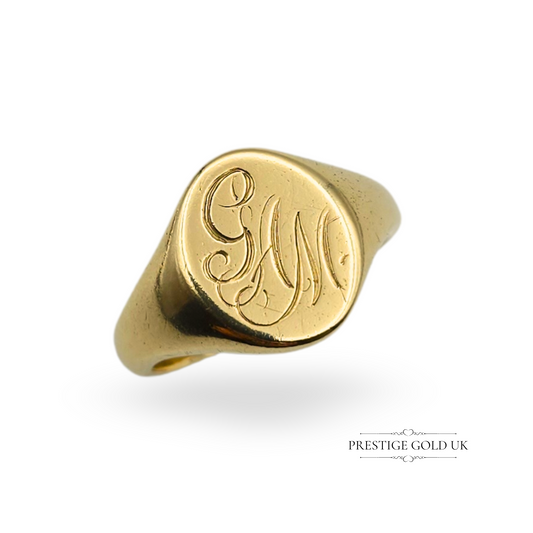 Photograph of a solid 9ct yellow gold men’s signet ring with an engraved “GAM” monogram, fully British hallmarked Birmingham 1996, UK ring size T / US 9½, polished finish and traditional oval face, heavy and high-quality vintage piece.