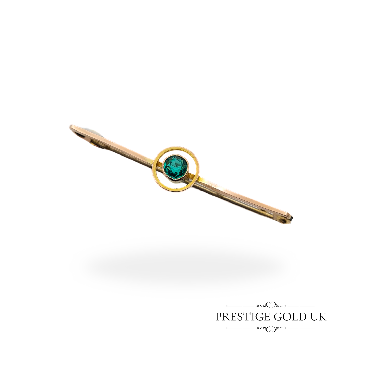 Antique 9ct rose gold emerald brooch featuring a circular bezel-set green stone, displayed against a neutral background.