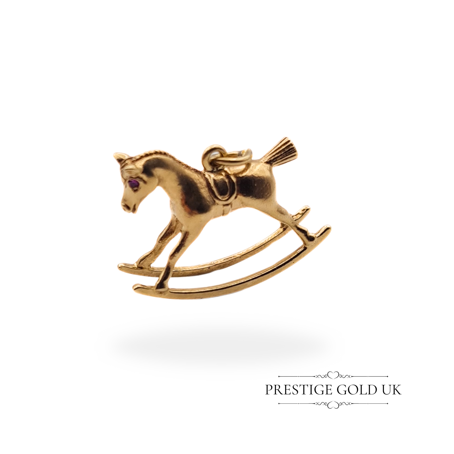 Close-up of a vintage 9ct gold solid rocking horse charm, featuring red stone eyes and detailed craftsmanship, fully hallmarked Birmingham 1973.