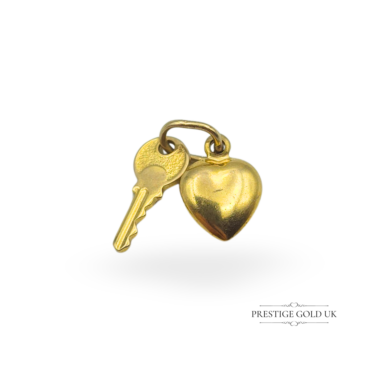 Vintage 9ct gold heart and key charm pendant, featuring a delicate 10mm heart and 12mm key, fully tested as 9ct gold but not hallmarked. A romantic and sentimental jewellery piece, perfect for a charm bracelet or necklace, making it an ideal gift for a loved one.