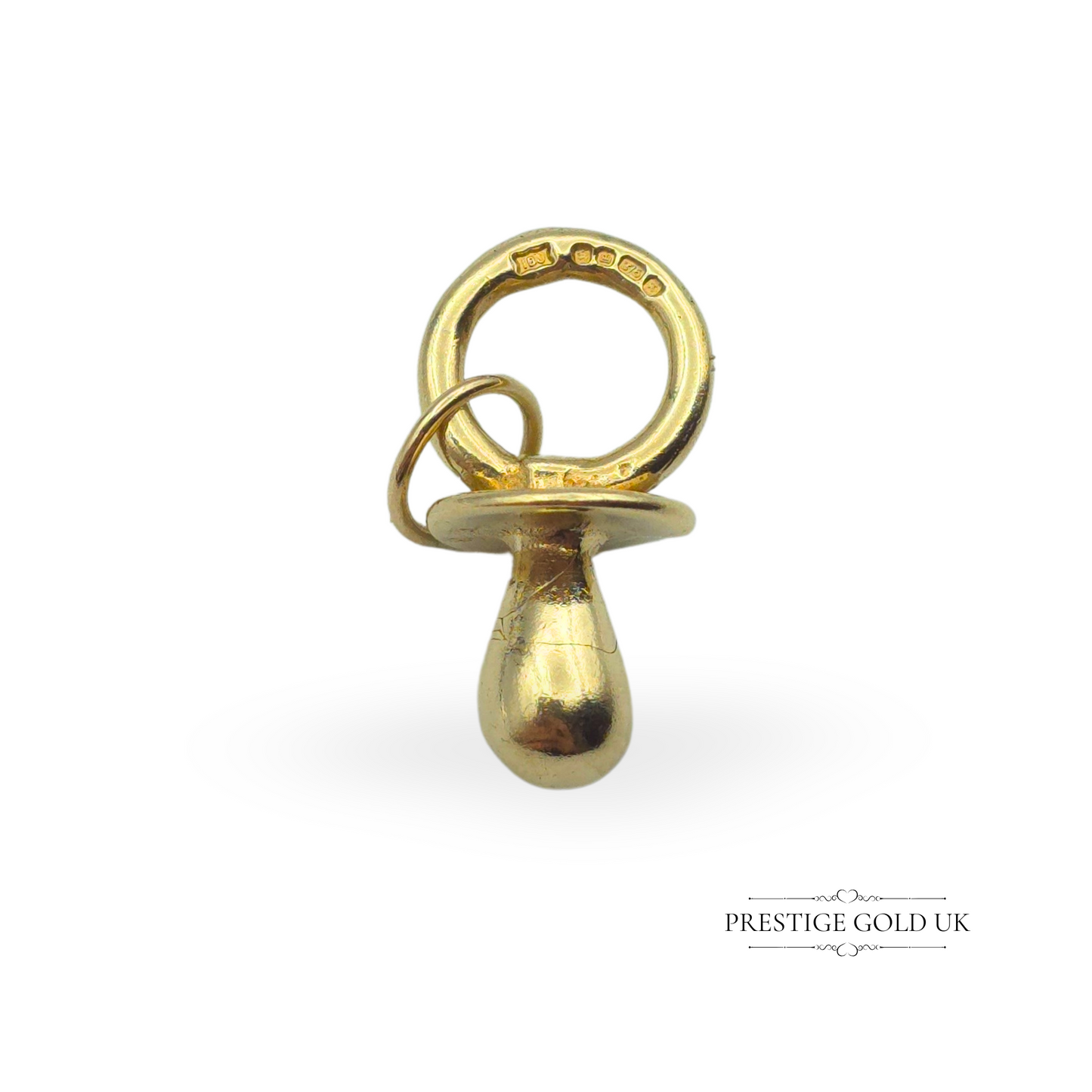A vintage 9ct gold sugar dummy charm, fully hallmarked Sheffield 1977, photographed on a finger to show scale and intricate details