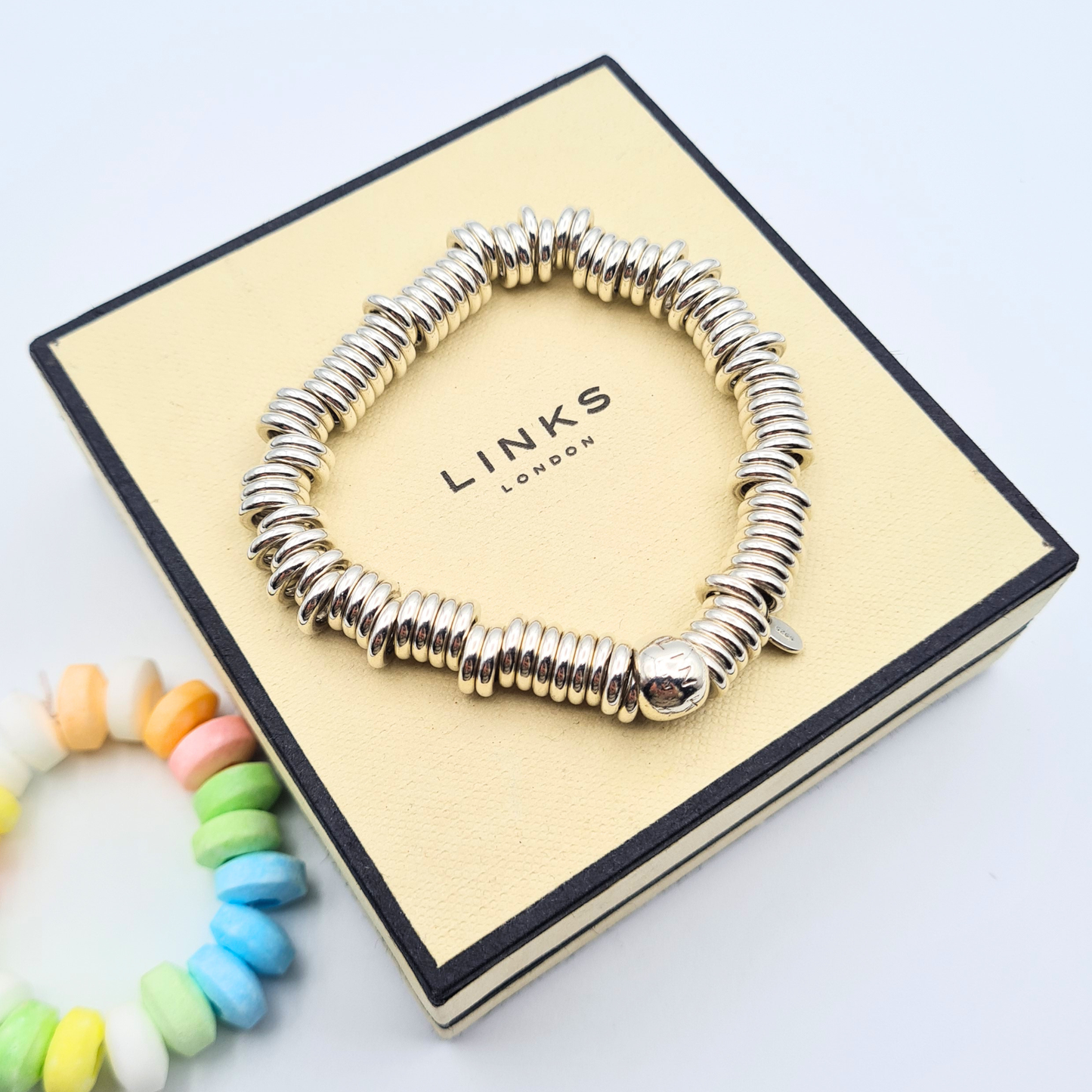 Sterling silver Links of London Sweetie bracelet with polished ring link design and elastic construction, measuring 6 inches, fully hallmarked with branded bead detail, chunky tactile silver bracelet shown on wrist and ruler for scale