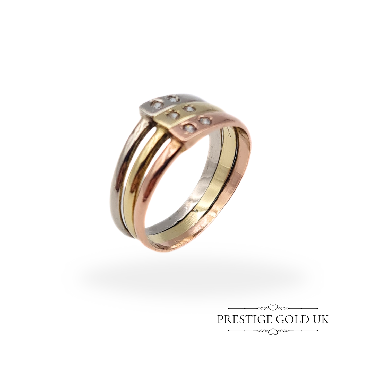 A vintage 14ct tri-tone gold triple-band ring featuring white, yellow, and rose gold, with sparkling spinel stones set in a connected design.