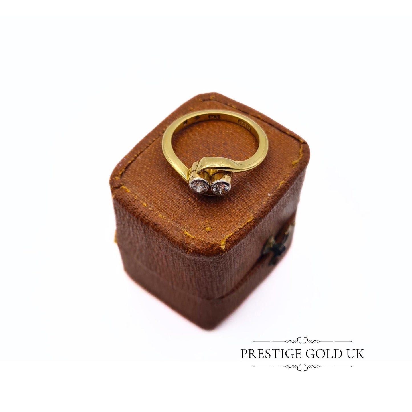 18ct gold crossover ring featuring two 0.03-carat diamonds, size UK I, with a stamped 18K hallmark and 2.6 grams weight. Elegant design with delicate diamond accents, perfect for a refined, sophisticated look.