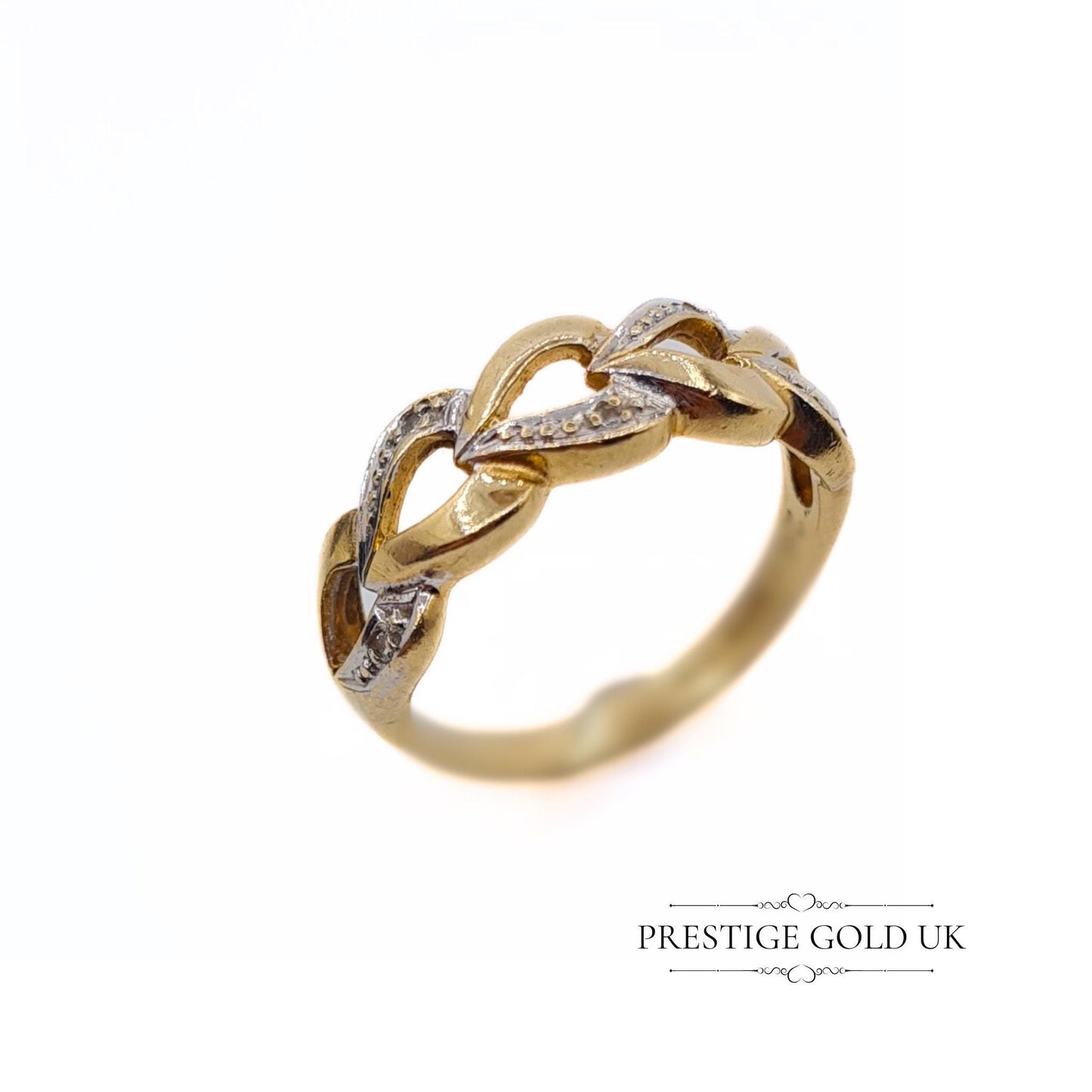 A 1993 British-hallmarked 9ct white and yellow gold ring with interlocking diamond-set hearts and a tapered band, ideal for jewellery lovers and collectors of romantic designs.