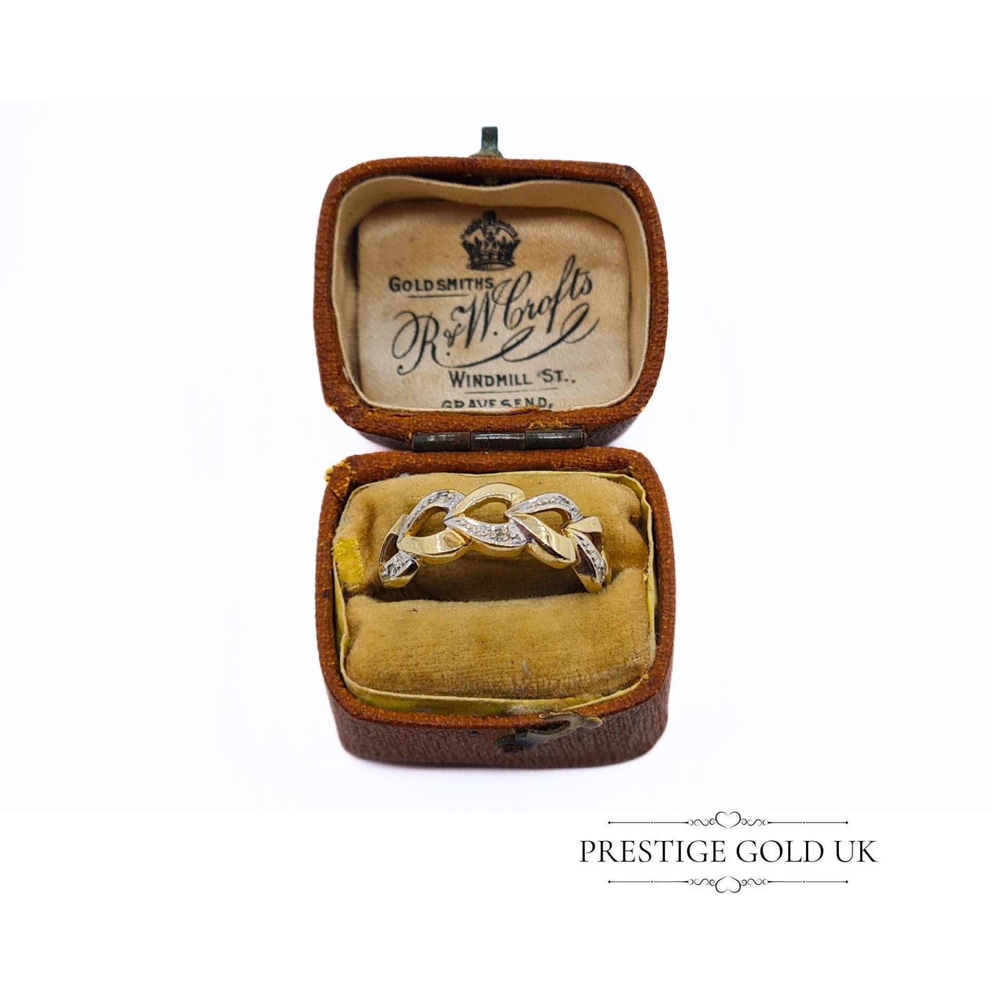 A 1993 British-hallmarked 9ct white and yellow gold ring with interlocking diamond-set hearts and a tapered band, ideal for jewellery lovers and collectors of romantic designs.