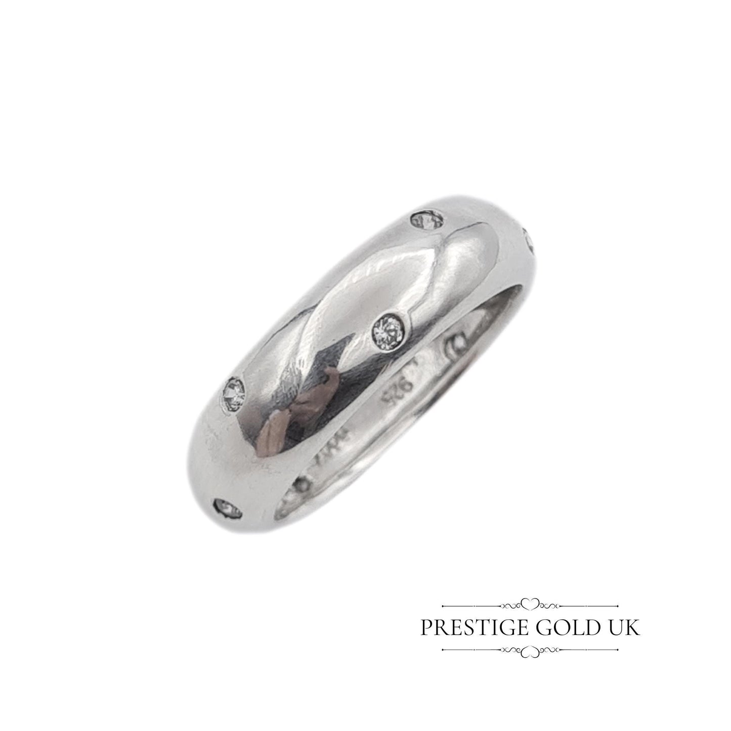 A 6mm wide sterling silver band ring with sparkling white stones, stamped 925 for authenticity. Features a beautiful, eye-catching design. Available in UK size R, US size 8 3/4, and Euro size 59. f sparkle to any outfit.