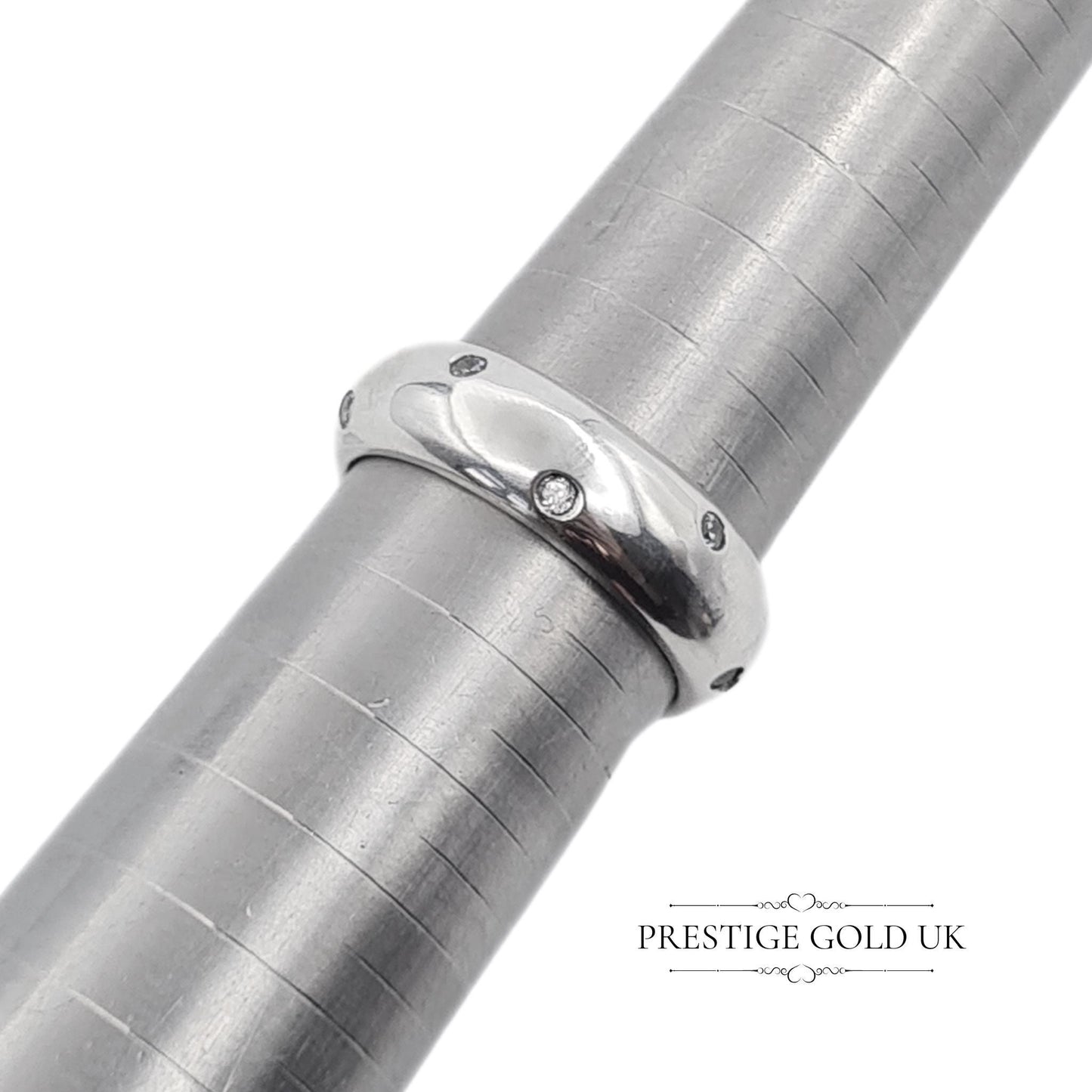 A 6mm wide sterling silver band ring with sparkling white stones, stamped 925 for authenticity. Features a beautiful, eye-catching design. Available in UK size R, US size 8 3/4, and Euro size 59. f sparkle to any outfit.