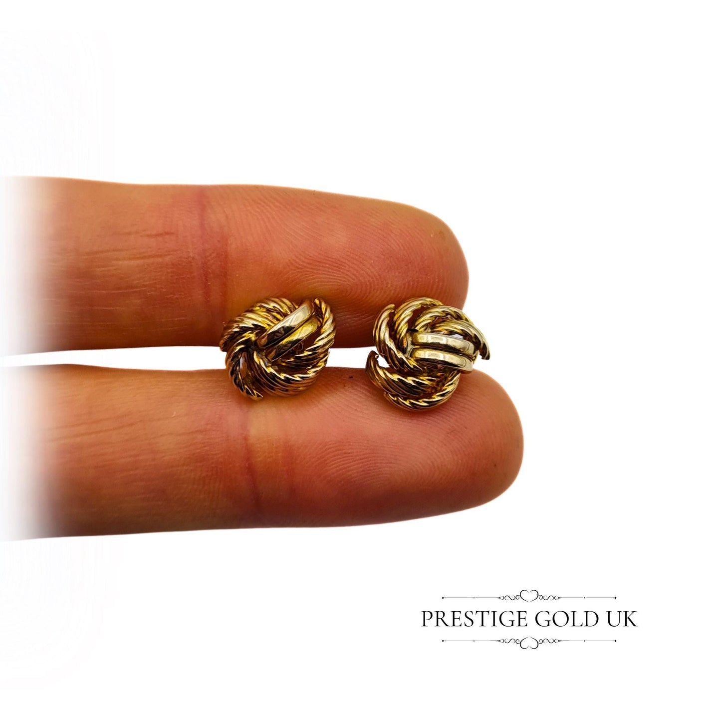 A pair of gold stud earrings resting on fingertips, demonstrating their lightweight and elegant size.