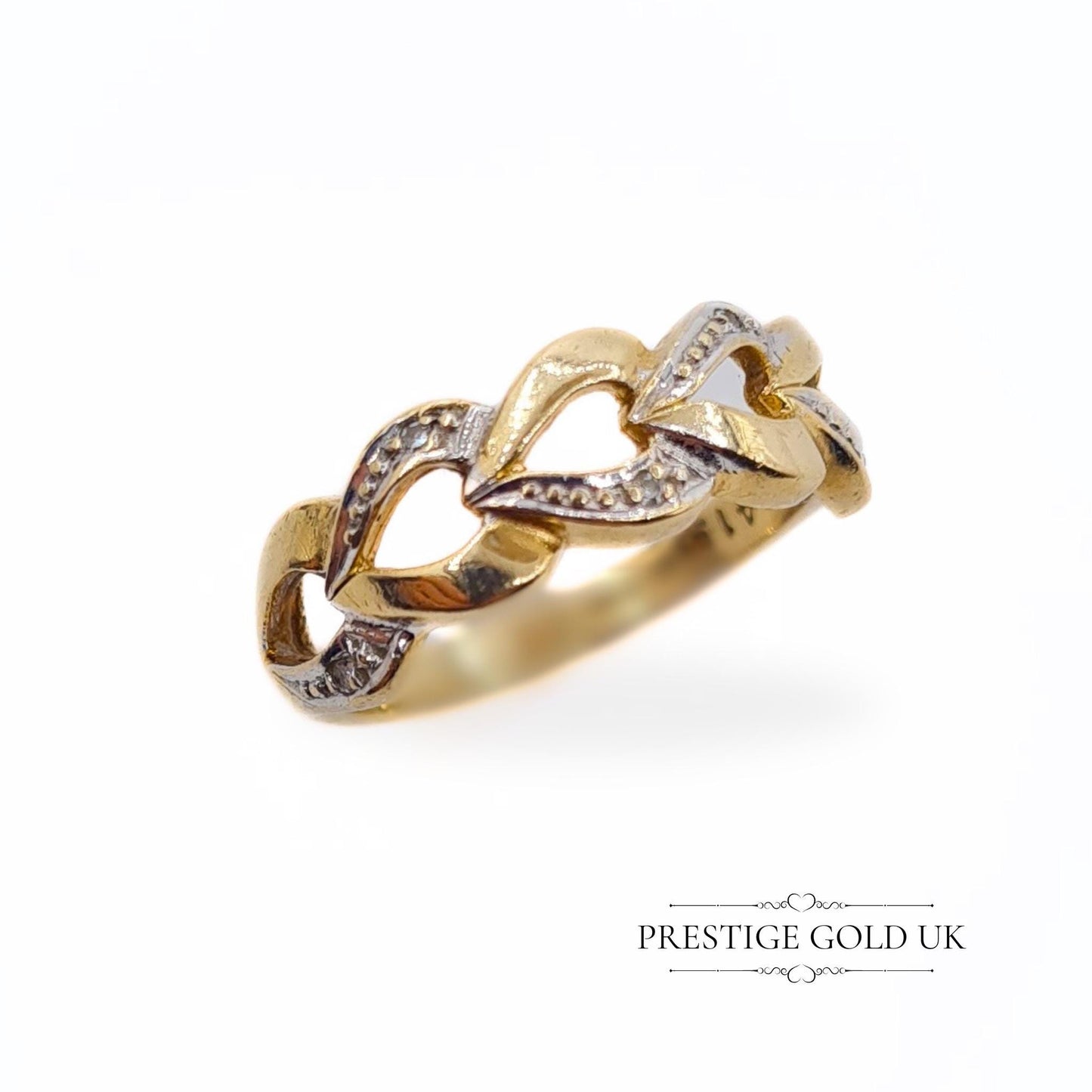A 1993 British-hallmarked 9ct white and yellow gold ring with interlocking diamond-set hearts and a tapered band, ideal for jewellery lovers and collectors of romantic designs.