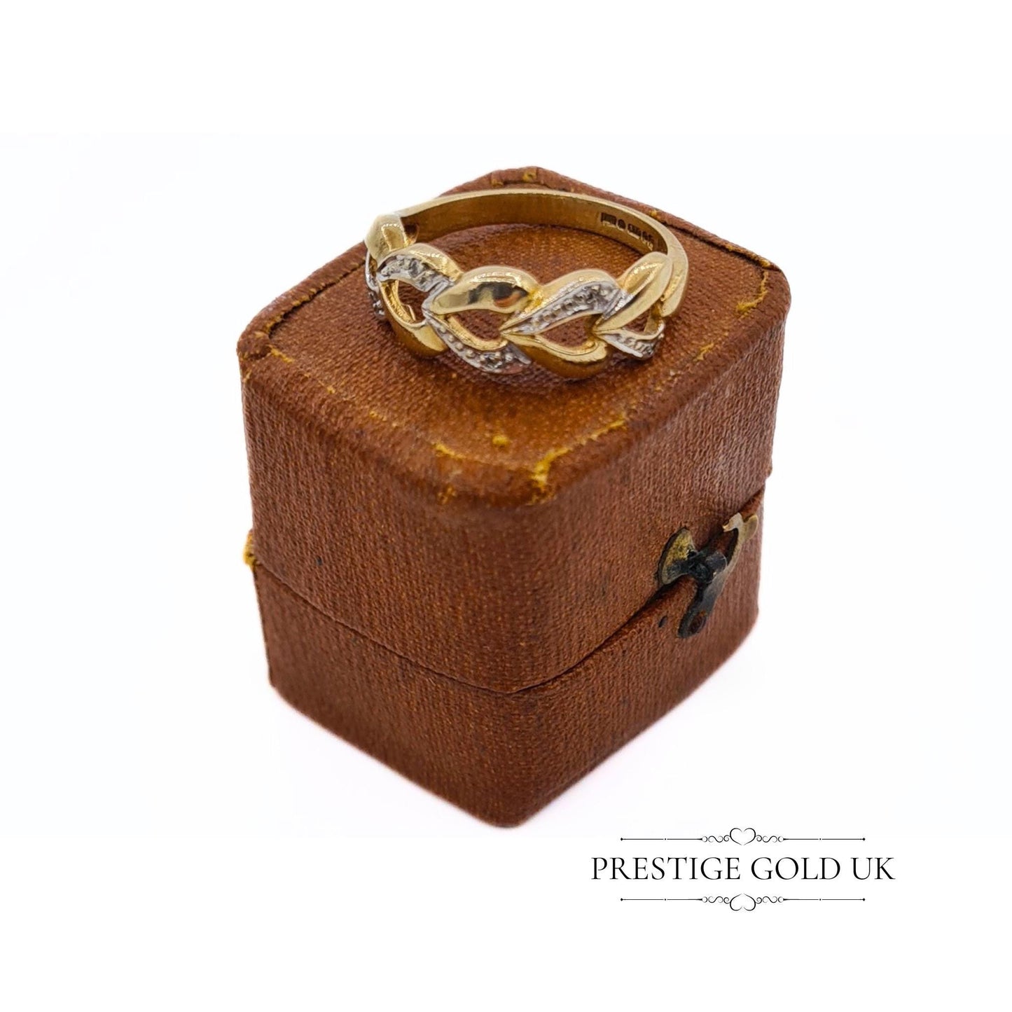 A 1993 British-hallmarked 9ct white and yellow gold ring with interlocking diamond-set hearts and a tapered band, ideal for jewellery lovers and collectors of romantic designs.