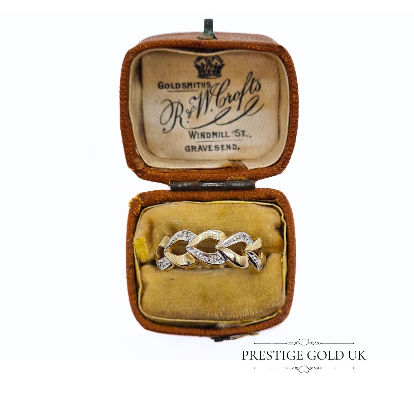 A 1993 British-hallmarked 9ct white and yellow gold ring with interlocking diamond-set hearts and a tapered band, ideal for jewellery lovers and collectors of romantic designs.