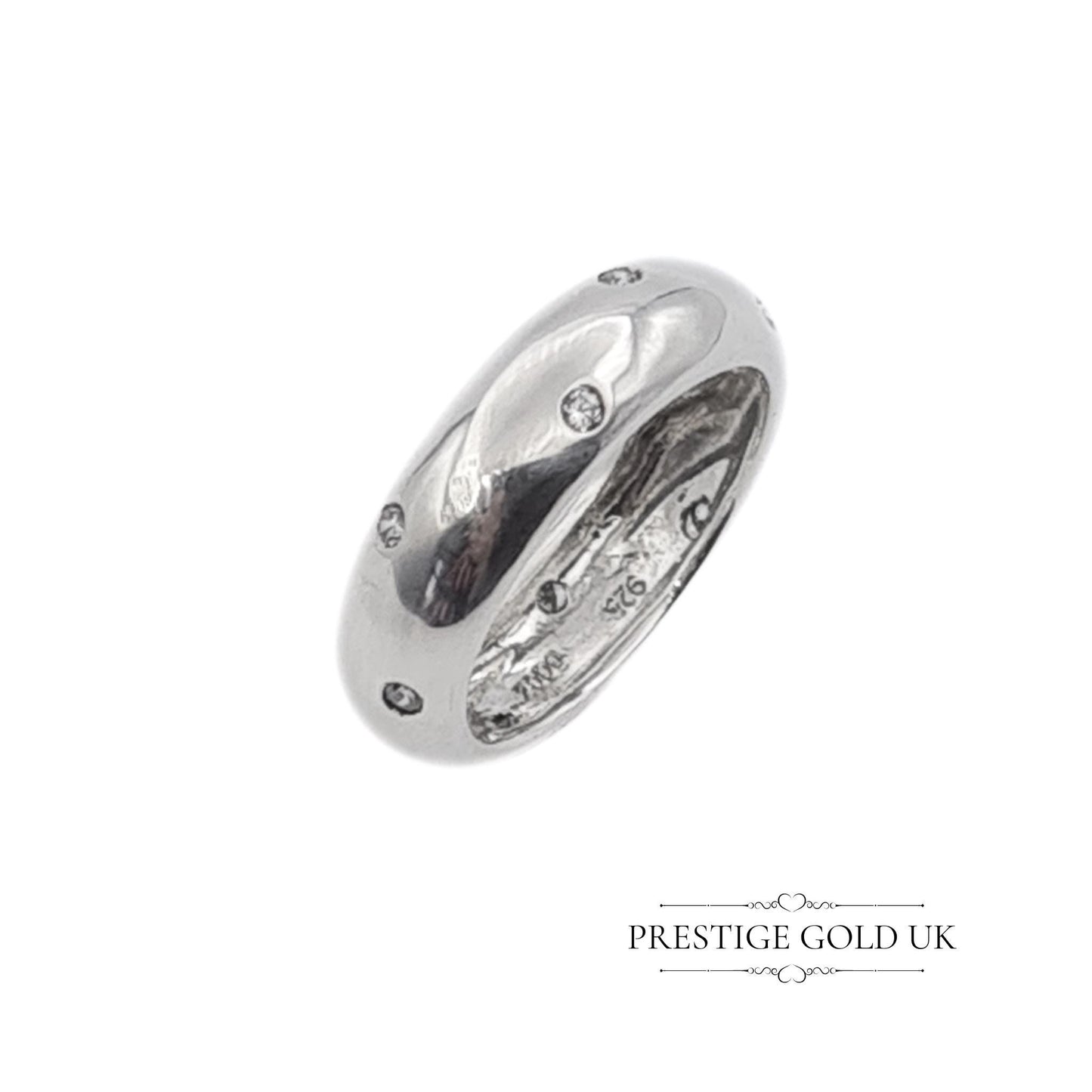 A 6mm wide sterling silver band ring with sparkling white stones, stamped 925 for authenticity. Features a beautiful, eye-catching design. Available in UK size R, US size 8 3/4, and Euro size 59. f sparkle to any outfit.