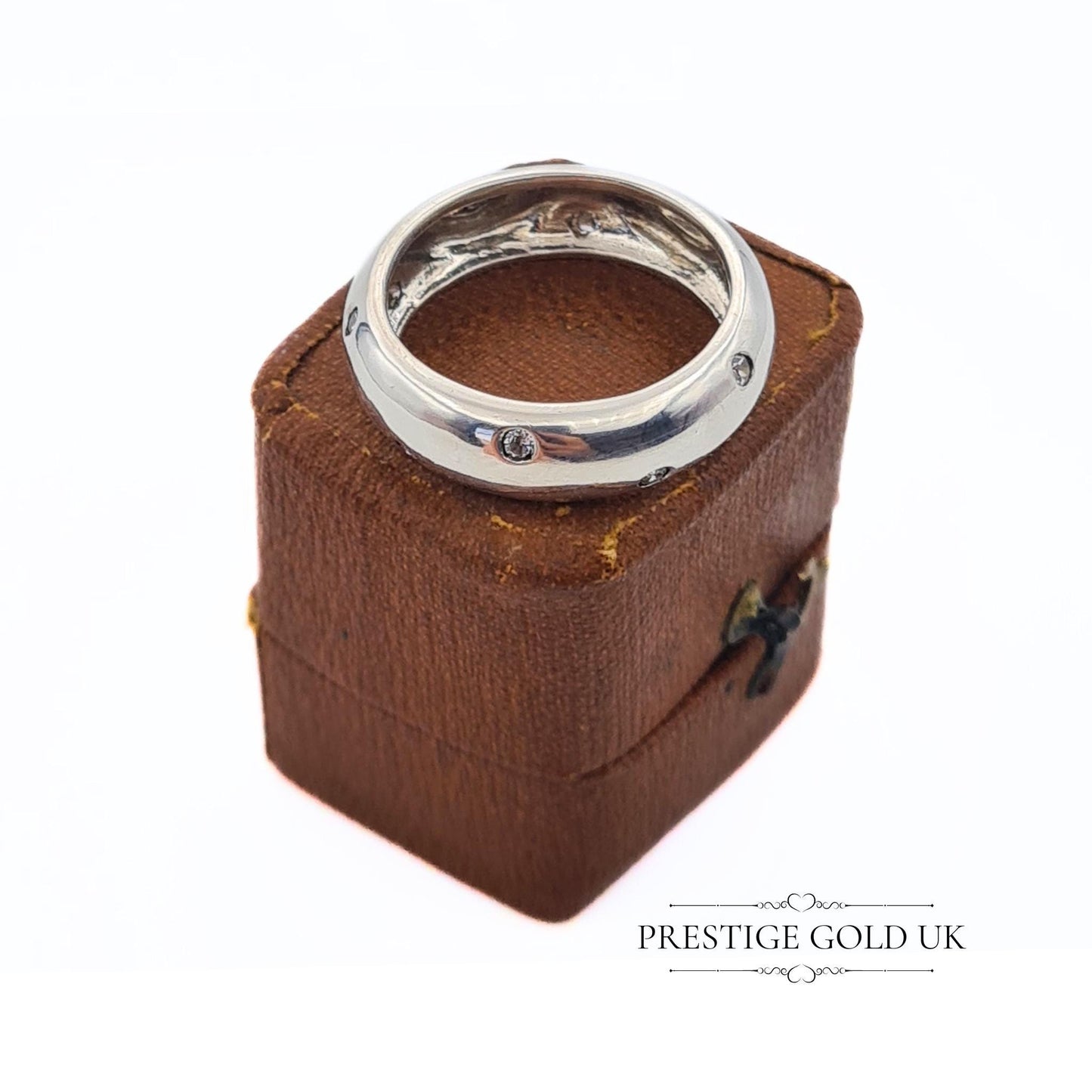 A 6mm wide sterling silver band ring with sparkling white stones, stamped 925 for authenticity. Features a beautiful, eye-catching design. Available in UK size R, US size 8 3/4, and Euro size 59. f sparkle to any outfit.