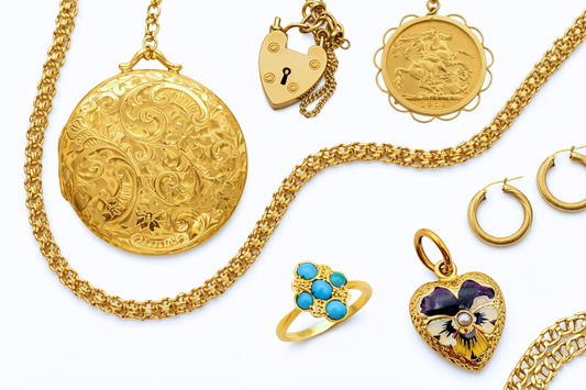 Collection of antique gold jewellery including lockets, charms and pendants arranged neatly on a clean white background