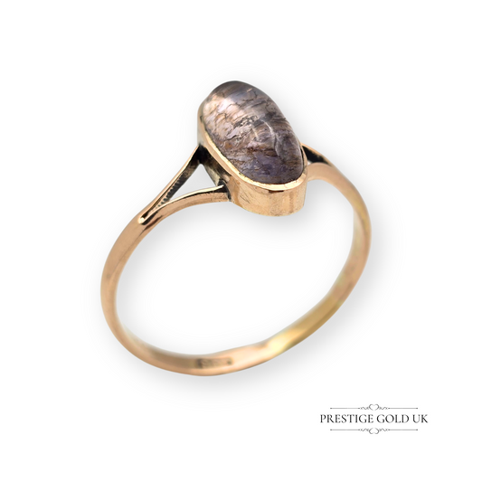 Antique 9ct rose gold ring featuring an oval cabochon-cut quartz gemstone with purple-brown tones, bezel set with split shoulders, UK size U.