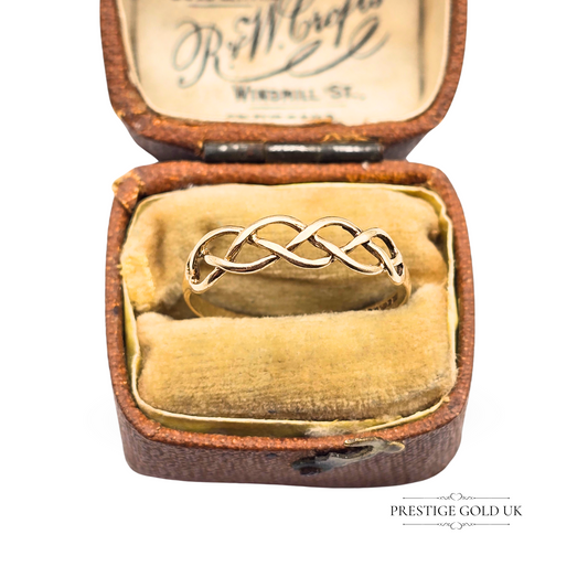 Delicate 9ct gold ring with a Celtic twist knot design, fully British hallmarked, lightweight and elegant, shown on ring mandrel and in antique box.