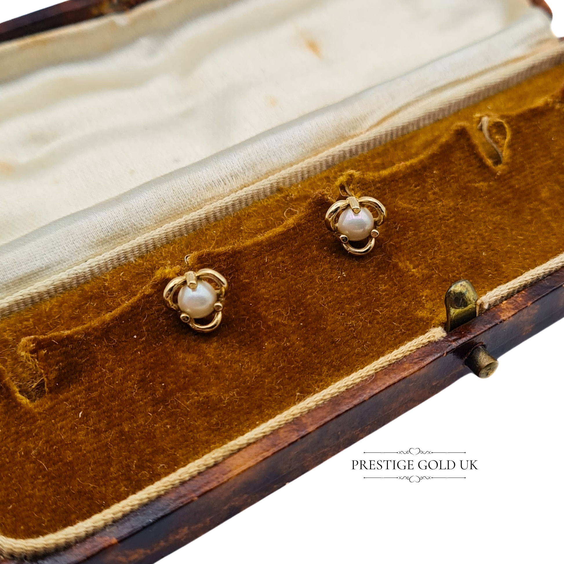 A pair of 9ct gold pearl studs resting in an antique velvet-lined jewellery box for a vintage aesthetic.