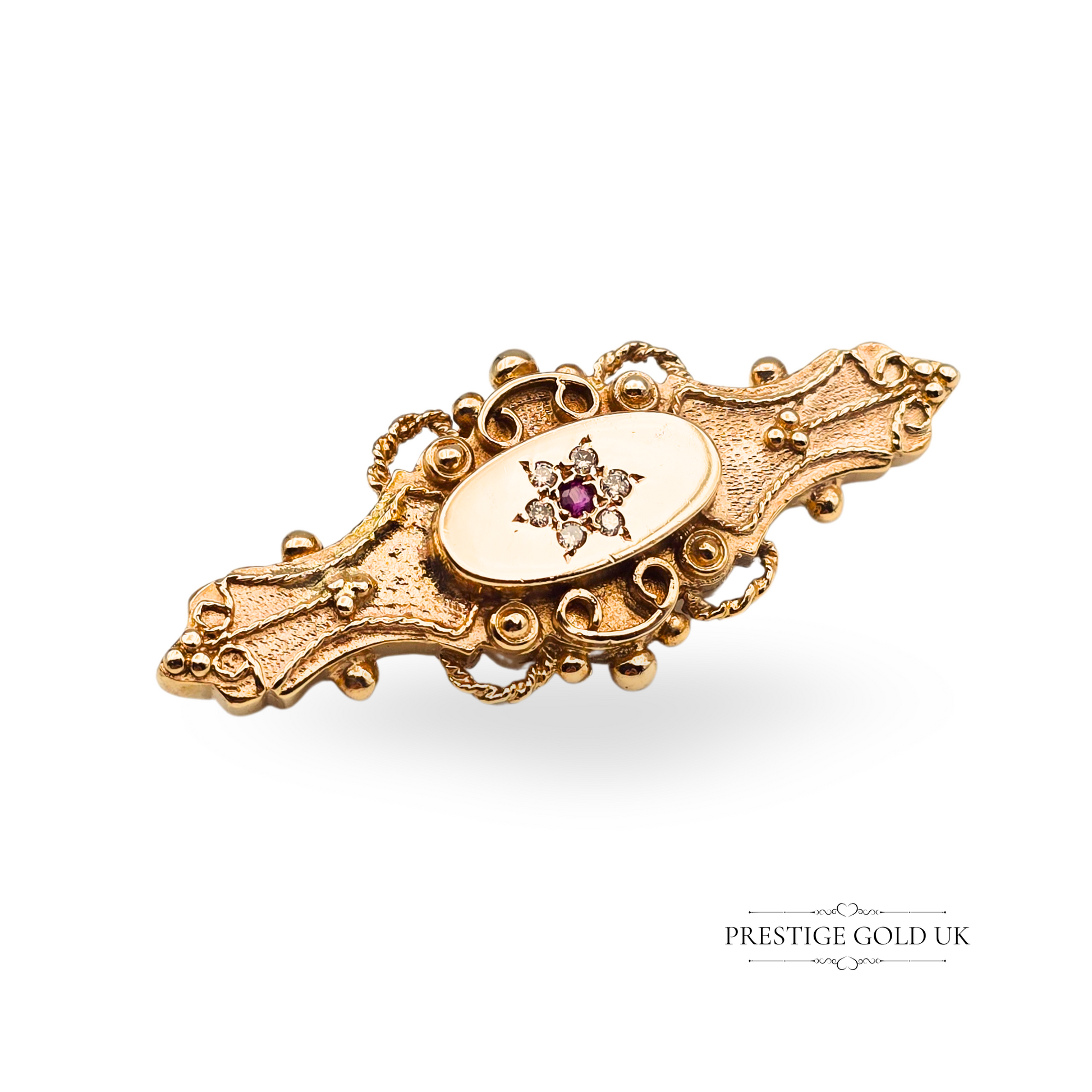 Vintage 9ct gold brooch with oval rubies and accent diamonds, set in an elegant twisted scroll frame. Fully hallmarked at Birmingham, this 41mm brooch is a one-off estate jewellery piece ideal for gifting or collectors.