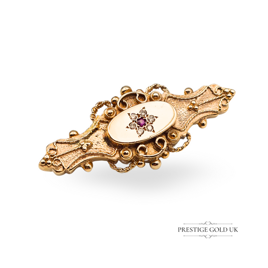 Vintage 9ct gold brooch with oval rubies and accent diamonds, set in an elegant twisted scroll frame. Fully hallmarked at Birmingham, this 41mm brooch is a one-off estate jewellery piece ideal for gifting or collectors.