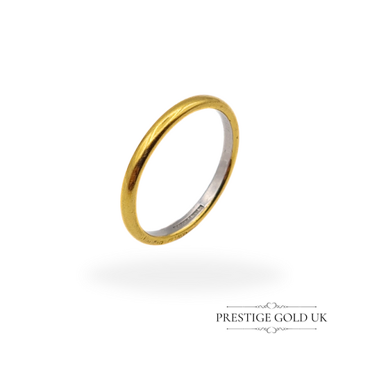 Vintage 18ct yellow gold and platinum wedding band displayed on a ring mandrel, showing its smooth and elegant design.