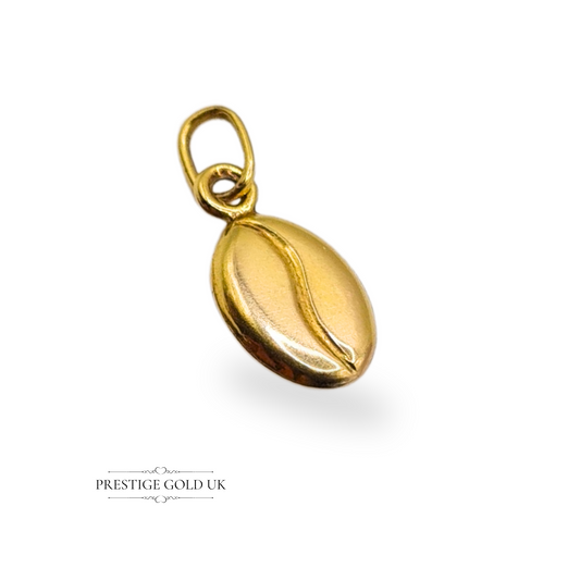 Close-up of a small 9ct yellow gold coffee bean charm, stamped 9K, 10mm long including jump ring and 7mm wide, with a smooth polished finish.

