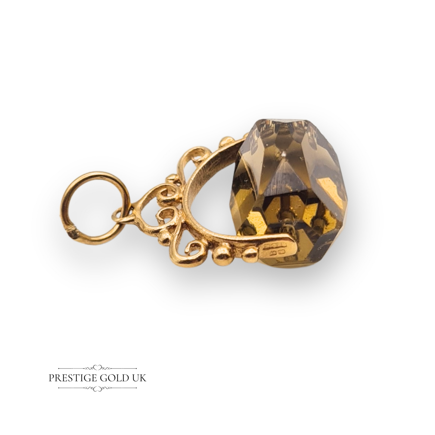Close-up of a 9ct gold swivel fob charm with faceted smoky quartz-style gem, scrollwork frame, fully hallmarked Birmingham 1974, antique Victorian style.