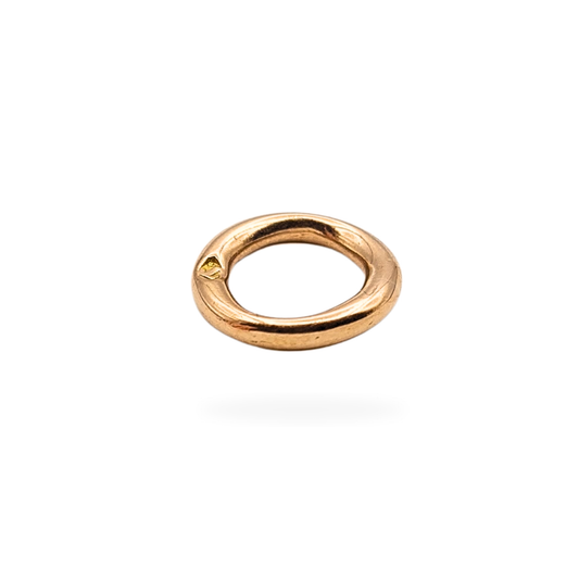 Close-up of a vintage 9ct rose gold closed jump ring with a “T” date stamp for 1943, measuring 9mm in diameter and 1.5mm wide. Tested as 9ct gold, this solid, soldered ring weighs 0.47g and is ideal for jewellery restoration or antique bracelet repair.