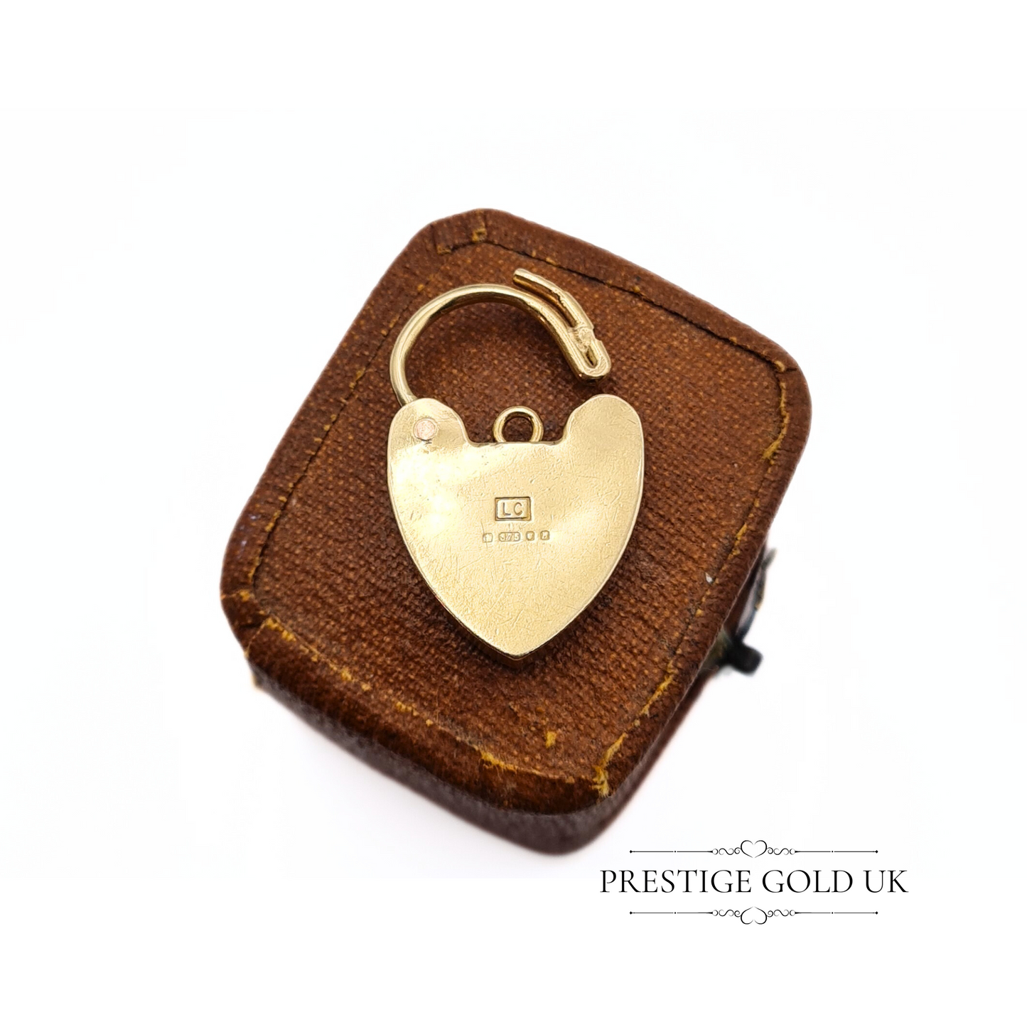 Rear view of the gold padlock charm, showing visible wear on the back and the LC maker’s mark.