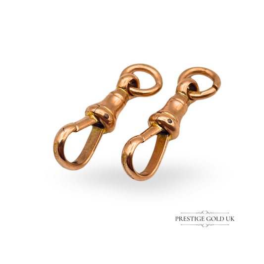 Antique 9ct rose gold dog clip clasps, matching pair, 24mm long each and weighing 3.3g combined. Stamped 375 with a traditional fixed bell-top design, ideal for Albert chains, charms or fob restoration. Warm rose gold, excellent vintage detail.