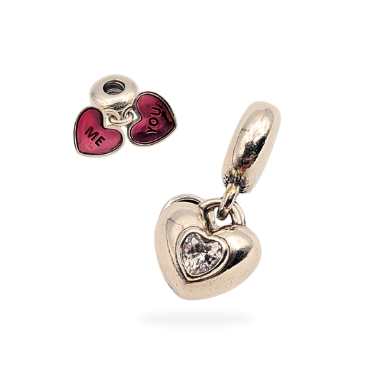 Pandora You & Me Split Heart charm crafted in sterling silver with S925 ALE hallmark. Features red enamel hearts engraved “ME” and “YOU” and heart-shaped CZ stones. Measures 11mm x 11mm, total weight 6.53g, excellent condition.