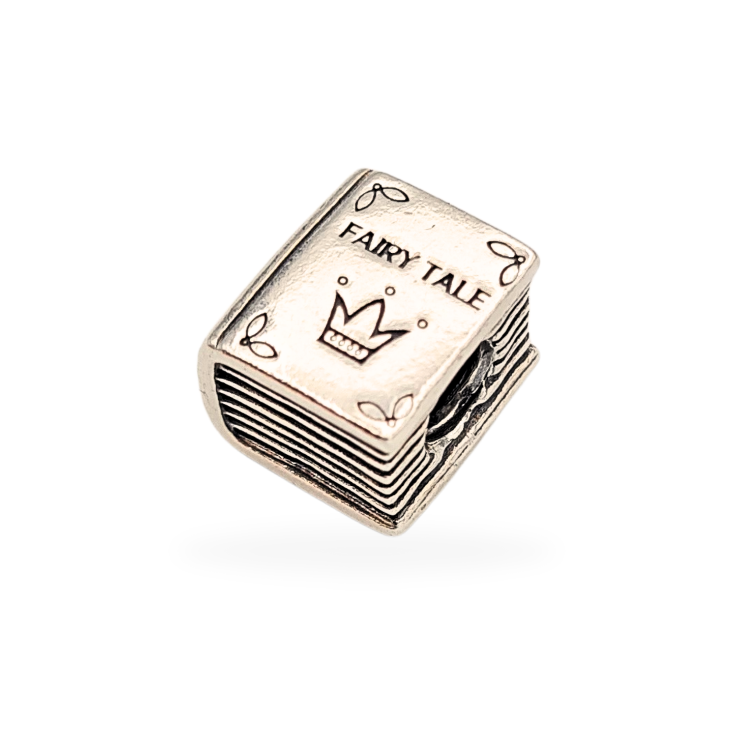 Close-up of a retired Pandora Fairy Tale Book charm in sterling silver, hallmarked S 925 ALE, featuring engraved crown and “FAIRY TALE” text on one side and a princess-and-frog motif on the other, measuring 10x9x7mm, 4.9g.
