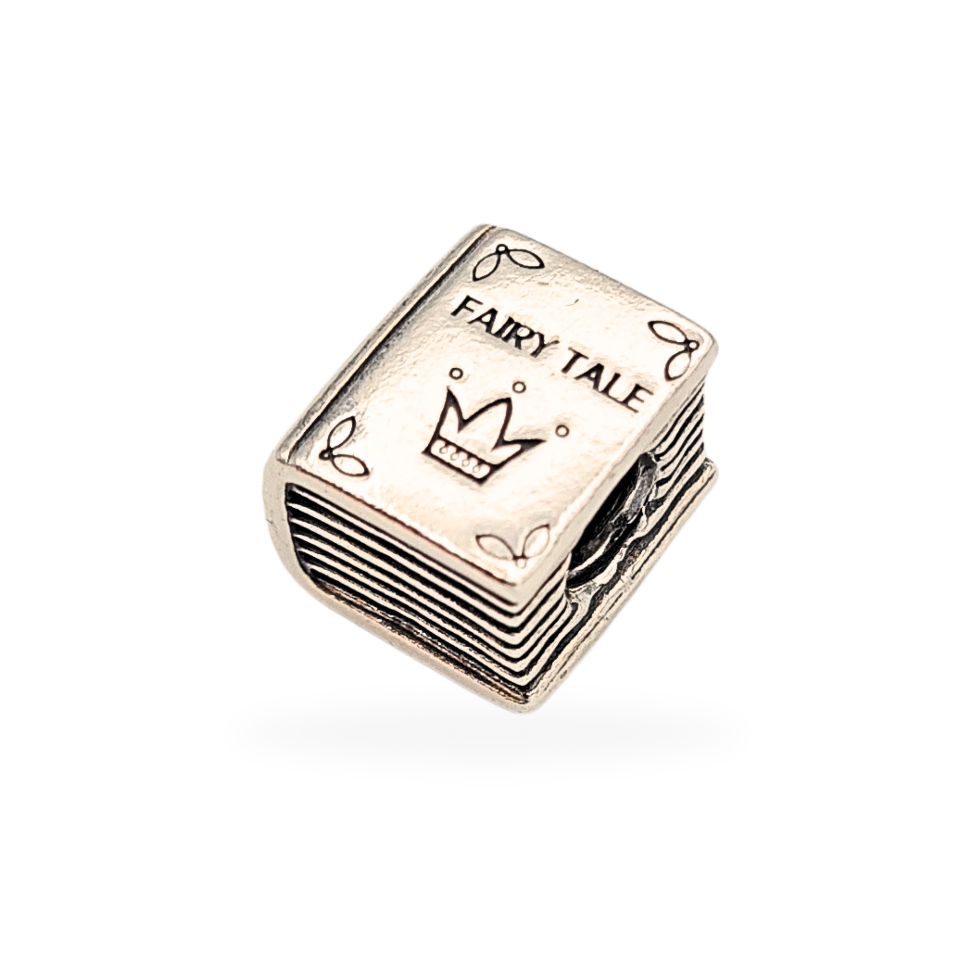 Close-up of a retired Pandora Fairy Tale Book charm in sterling silver, hallmarked S 925 ALE, featuring engraved crown and “FAIRY TALE” text on one side and a princess-and-frog motif on the other, measuring 10x9x7mm, 4.9g.