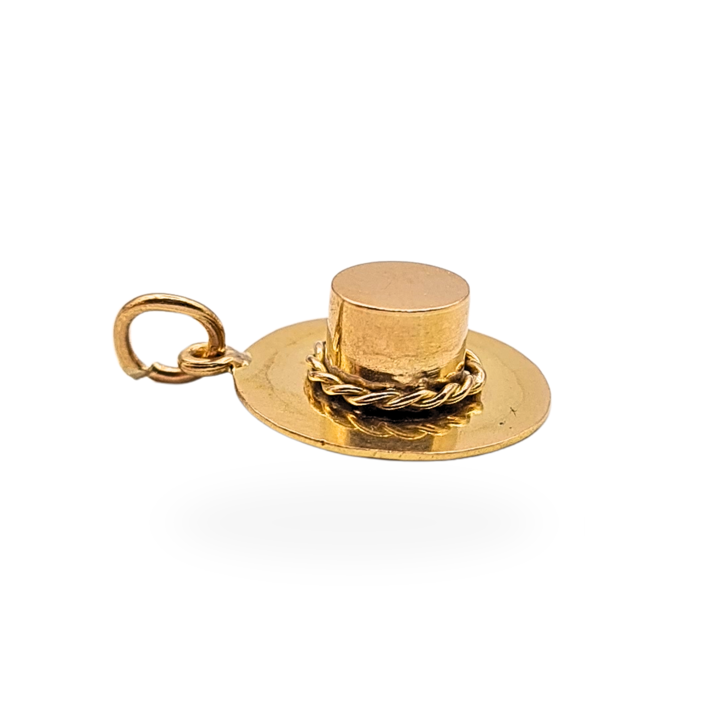 Small 9ct gold boater hat charm pendant measuring approximately 13mm wide and 4.5mm tall with miniature raised crown and twisted band detail. Fully tested gold novelty charm shown beside ruler and on fingertip for scale, suitable for bracelet or necklace charm jewellery.
