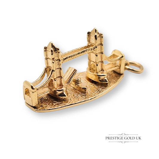 9ct yellow gold London Bridge charm featuring detailed twin towers, suspension cables, and textured base, measuring 28mm by 12mm, a British travel souvenir in polished solid gold
