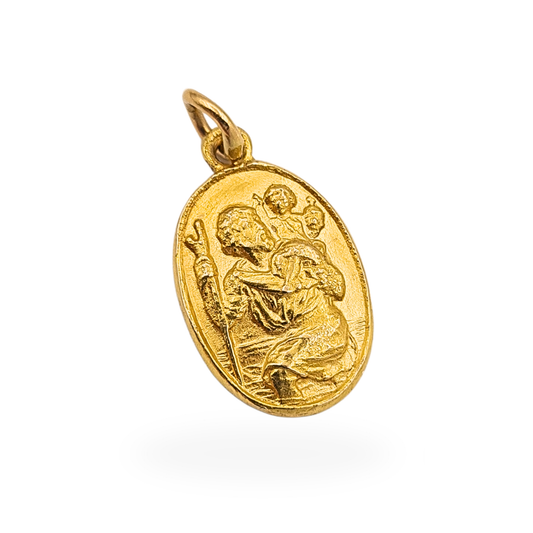 Vintage 9ct gold St Christopher oval pendant fully hallmarked Birmingham 1986, measuring approximately 18mm tall and 11mm wide. Solid gold religious medal showing Saint Christopher carrying the Christ child, photographed beside ruler and on fingertip for scale.