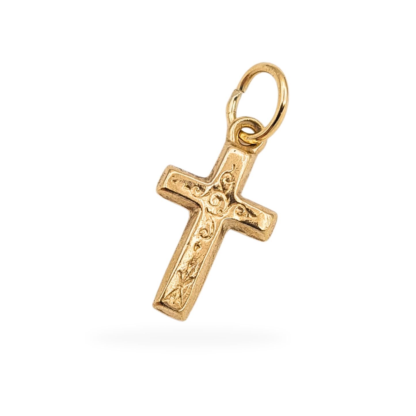 Tiny 9ct gold hollow cross pendant measuring 16mm tall and 9mm wide, engraved on both sides with scroll detail, fully tested and hallmarked on the jump ring with worn marks, lightweight 0.5g religious charm suitable for a fine chain or bracelet.