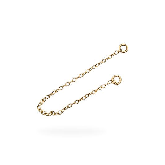 Close-up of a 9ct yellow gold safety chain with fine oval links and small jump rings at each end, measuring 2 1/3 inches (60 mm) long and weighing 0.16 g; tested as 9ct gold and displayed against a neutral background.