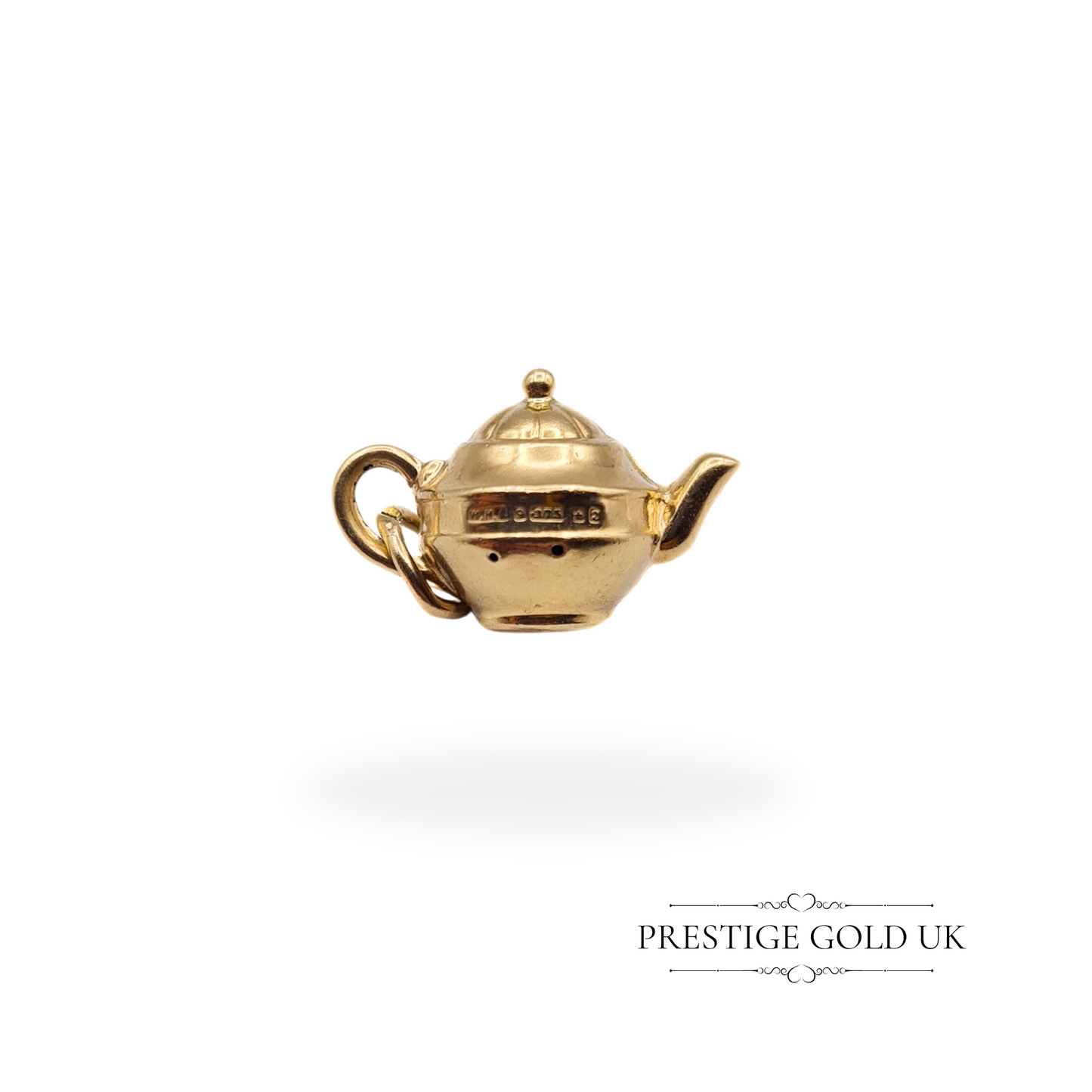 Petite gold teapot charm shown in hand, highlighting its lightweight and delicate craftsmanship.