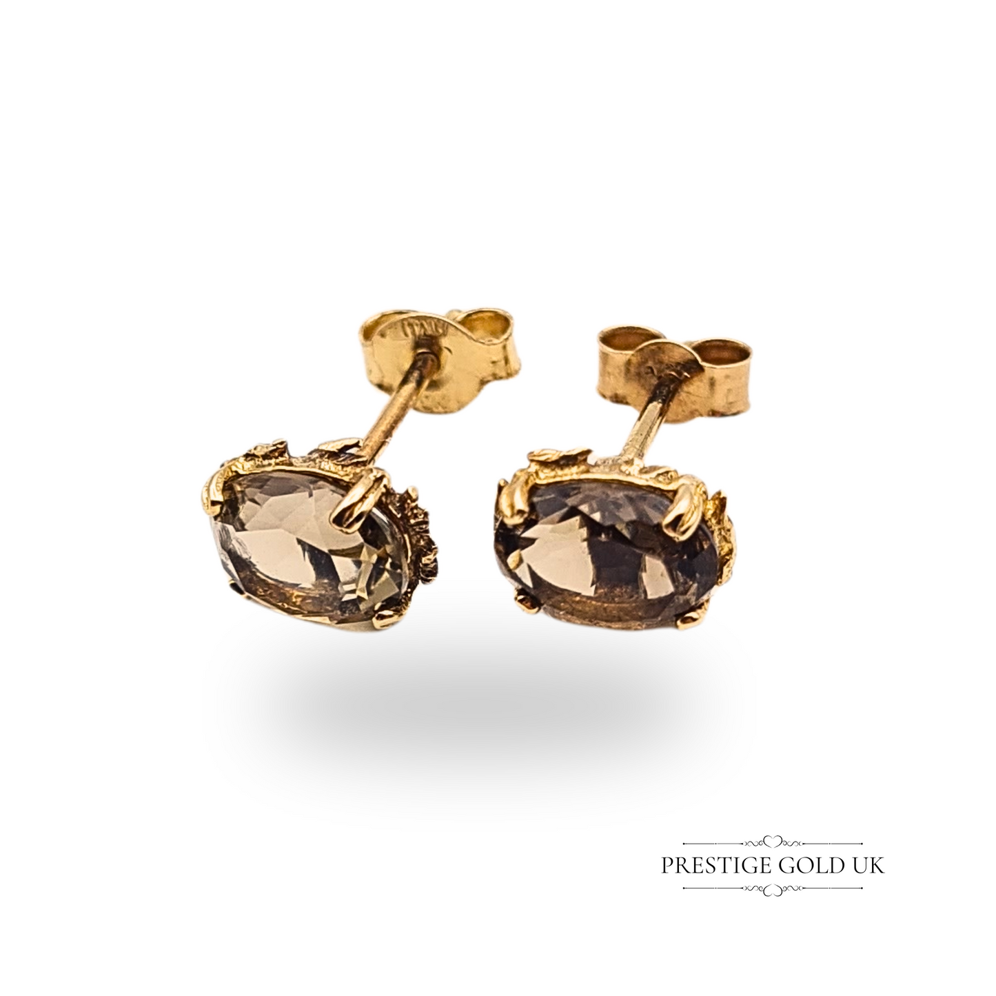 A pair of 9ct gold stud earrings featuring small oval claw-set smokey quartz gemstones, 8x6mm each, in a dainty and elegant antique-style gold setting.