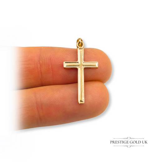 Solid 9ct gold crucifix pendant with hollow construction, measuring 25mm tall by 13mm wide, featuring a simple polished cross design and Birmingham hallmark.