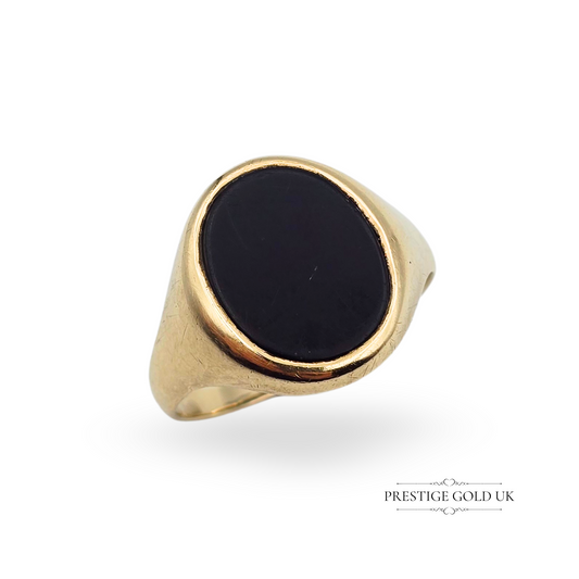 

Vintage 9ct yellow gold signet ring featuring an oval black onyx stone in a smooth bezel setting. UK size W, US size 11. Classic men's jewellery with worn hallmarks and timeless appeal.
