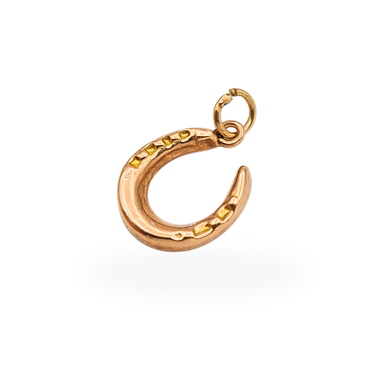 Tiny 9ct rose gold horseshoe charm with raised nail detailing and circular suspension ring