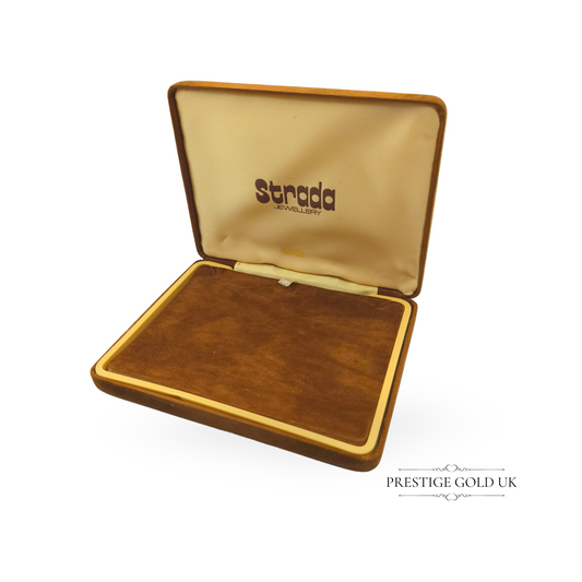 A vintage brown suede jewellery box by Strada Jewellery, featuring a plush velvet-lined interior. Designed to store and display necklaces, it measures 14.5cm long, 11.5cm deep, and 2.5cm tall. A luxurious and stylish storage option for vintage jewellery lovers.