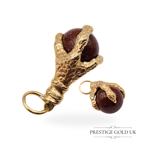 Close-up of a 9ct gold eagle claw charm gripping a spinning moonstone sphere, highlighting intricate detailing.