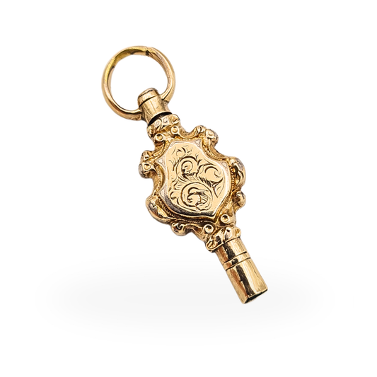 9ct gold miniature pocket watch winding key charm with ornate hand-engraved shield decoration