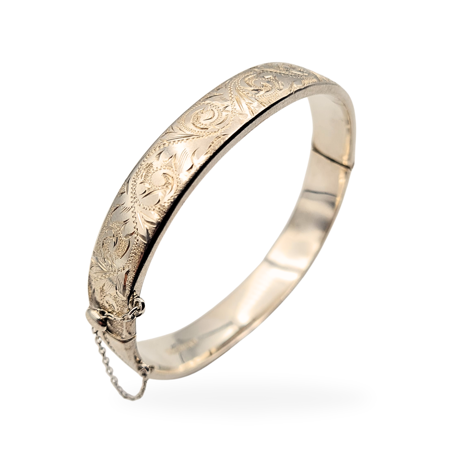 Sterling silver bangle with ornate botanical engraving, Birmingham 1992 hallmark, 7-inch oval design with push clasp and safety chain, 10mm wide and 15.2g in weight, finely detailed vintage British bracelet in excellent condition.