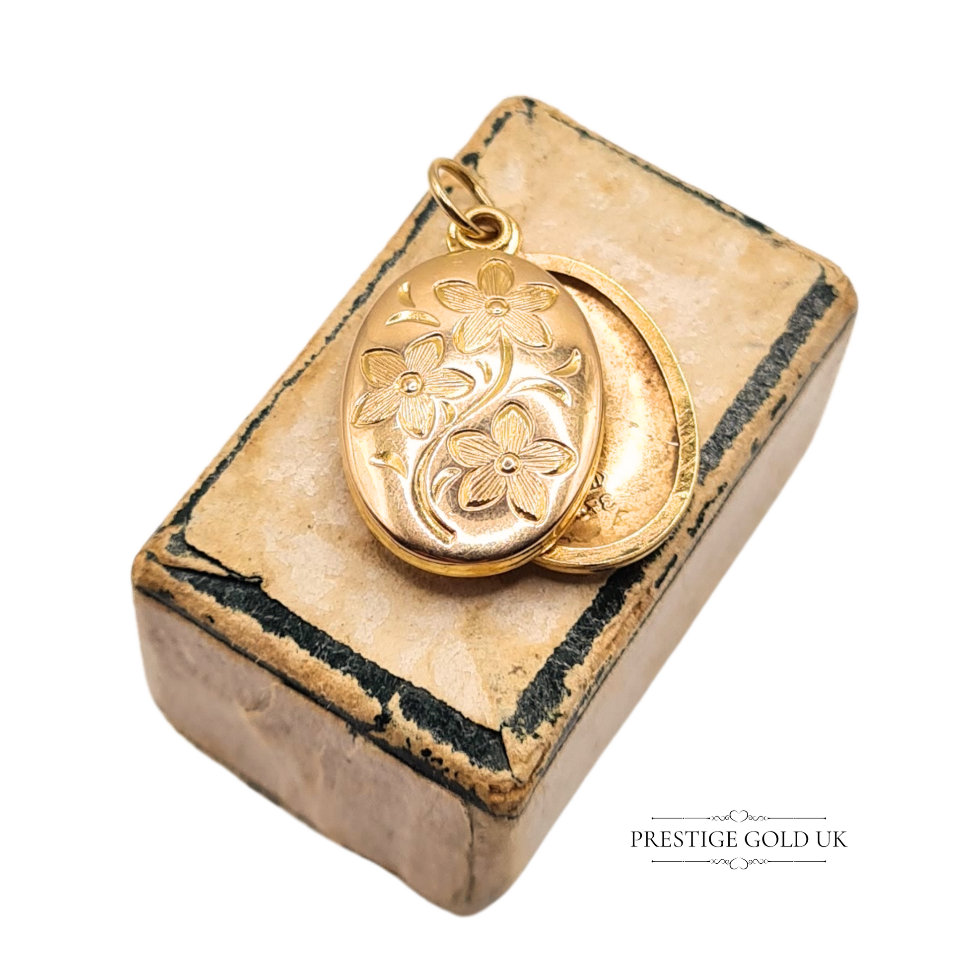 Oval 9ct yellow gold locket pendant with engraved floral design, measuring 18mm x 11mm, stamped 375, lightweight with slide opening, shown on scale.

