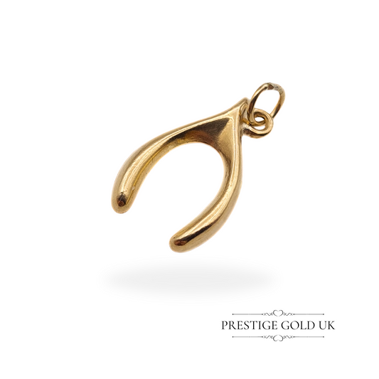 Small vintage 9ct gold wishbone charm with a sleek hollow design, fully hallmarked London 1981, 11mm long, displayed against a white background.
